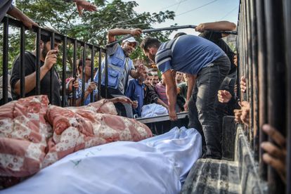 Palestinos transportan los cuerpos de las víctimas para darles sepultura, desde la morgue del hospital Nasser hasta el cementerio, este jueves en la ciudad de Jan Yunis.