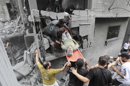 Palestinos sacan un hombre herido de entre los escombros, tras un ataque israelí, este viernes en la ciudad de Gaza.  